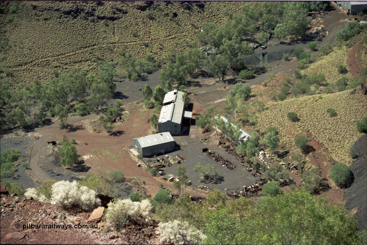 195-17
Wittenoom Gorge, Australian Blue Asbestos or ABA Colonial Mill view of stores or warehouse building and fenced yard and the maintenance workshop shed.
