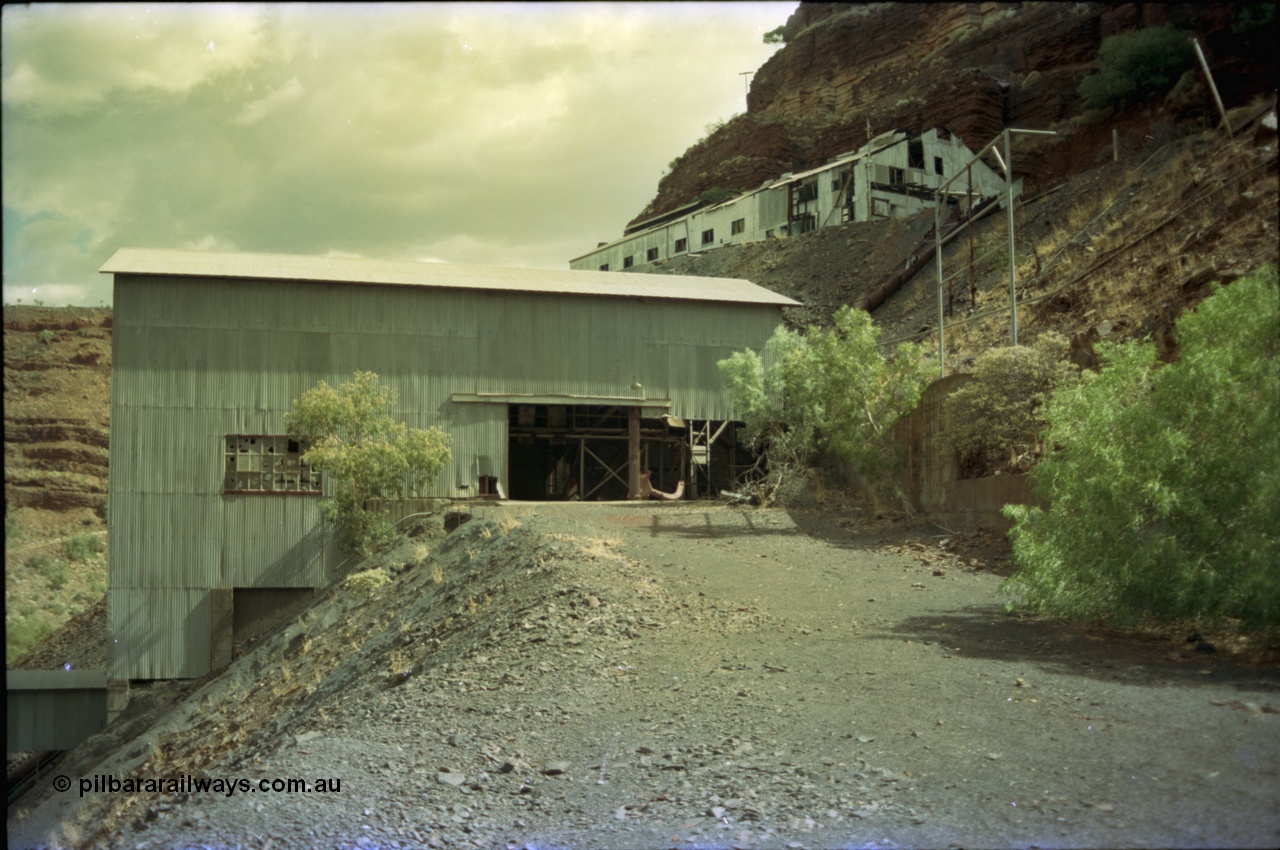 195-37
Wittenoom Gorge, Australian Blue Asbestos or ABA Colonial Mill, view of primary crushing building, shows metal slide chute from upper lever were the waggons are emptied, top building is the underground offices, change rooms etc.
