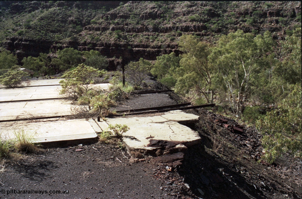 196-27
Wittenoom Gorge, Gorge Mine area, asbestos mining remains, view of demolished building with railway tracks in concrete floor, possible locomotive shop.
