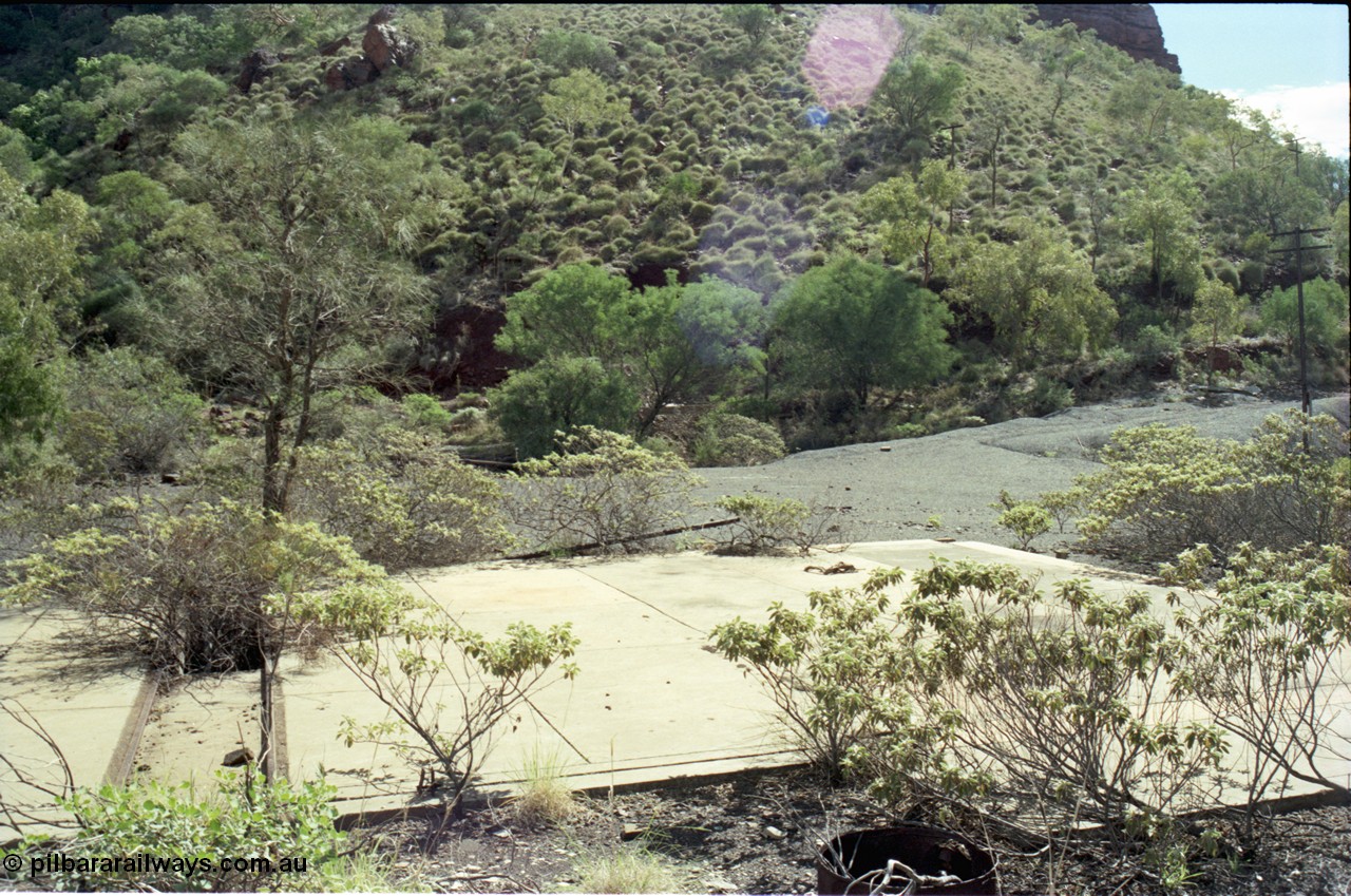 196-29
Wittenoom Gorge, Gorge Mine area, asbestos mining remains, view of demolished building with railway tracks and pit in concrete floor, locomotive workshops.
