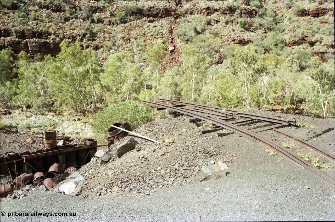 196-30
Wittenoom Gorge, Gorge Mine area, asbestos mining remains, view of demolished building with railway tracks in air, site of former dump or unloading station.
