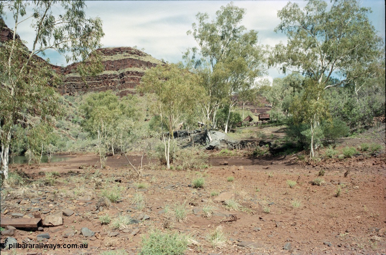 196-33
Wittenoom Gorge, Gorge Mine area, asbestos mining remains, view looking south up the gorge past the mill site of the river and tailings, ore waggons visible.
