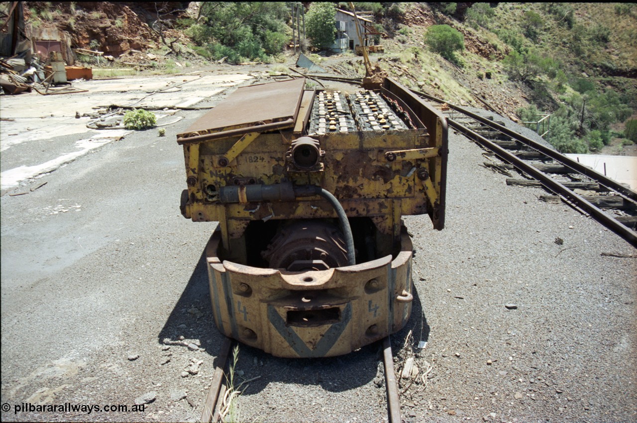 197-13
Wittenoom, Colonial Mine, asbestos mining remains, Mancha battery locomotive #4 looking north west, demolished workshops and office on the left, mine adit doors visible, compressor building in the distance.
Keywords: Mancha;