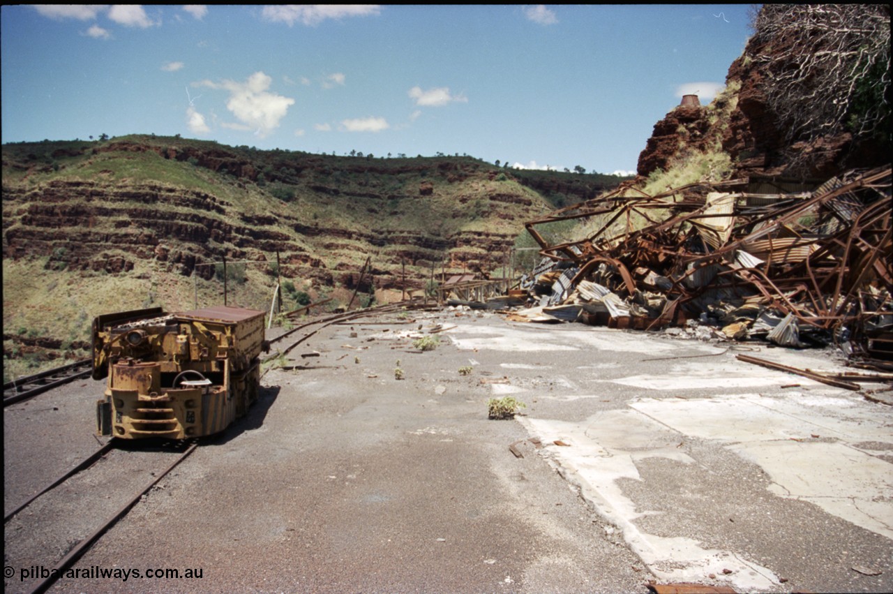 197-19
Wittenoom, Colonial Mine, asbestos mining remains, view looking south east with the demolished underground shit offices and workshops, Mancha battery locomotive #4 and the battery charging shed remains just visible in the distance.
Keywords: Mancha;