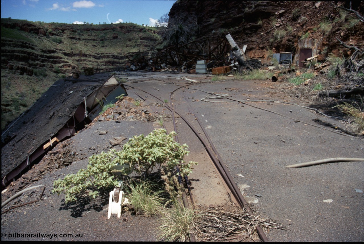 197-23
Wittenoom, Colonial Mine, asbestos mining remains, view of the points leading to the mine adit on the right, and past the discharge slide chute on the left. The loop road is visible in the distance, with the demolished underground offices and lamp room pushed up against the gorge wall. Mancha #4 in the distance.
Keywords: Mancha;