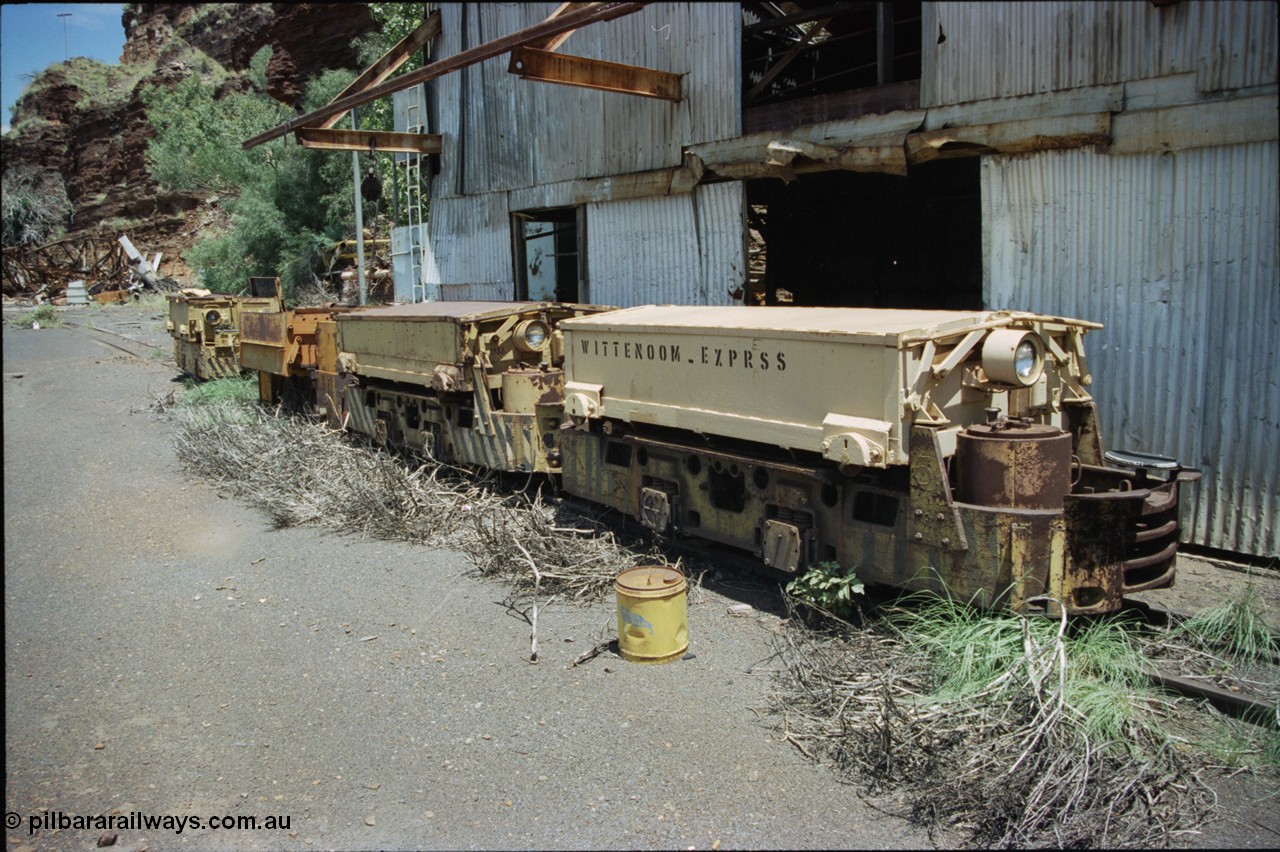 197-32
Wittenoom, Colonial Mine, asbestos mining remains, line up of two Mancha locomotives and the Gemco, then an English Electric. In the background is the demolished locomotive changing and maintenance shed. The building on the right are more workshops, the lead unit has Wittenoom Express stencilled on the battery box, this unit now resides at the Pilbara Railways Historical Society 6 Mile Museum near the Rio Tinto 7 Mile complex in Dampier.
Keywords: Mancha;English-Electric;Gemco;