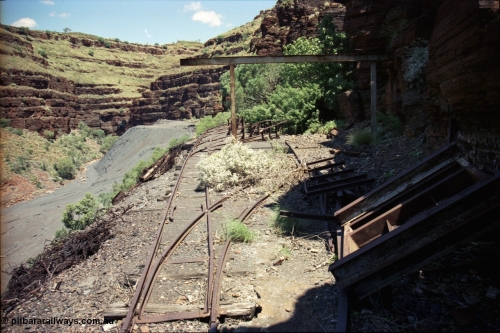 197-10
Wittenoom, Colonial Mine, asbestos mining remains, view looking south west of the open air service pit with gantry and locomotive storage roads with the battery off-take racks. The track used to continue around to the mine adits in the background.

