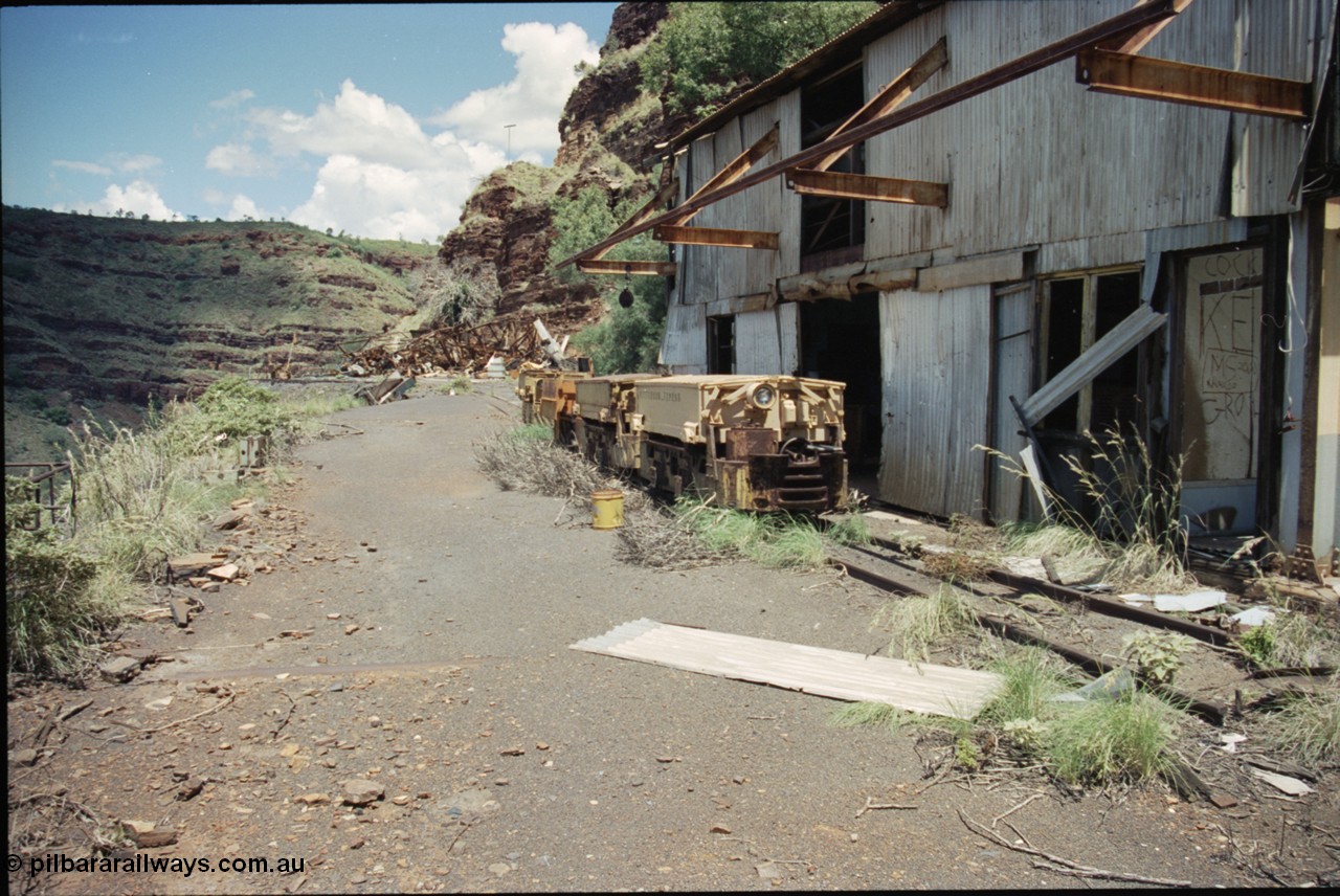 198-06
Wittenoom, Colonial Mine, asbestos mining remains, line up of two Mancha locomotives and the Gemco, then an English Electric unit. The compressor and water treatment plant is beside the locos, In the distance is the demolished locomotive changing and maintenance shed and underground offices and lamp room.
Keywords: Mancha;English-Electric;Gemco;