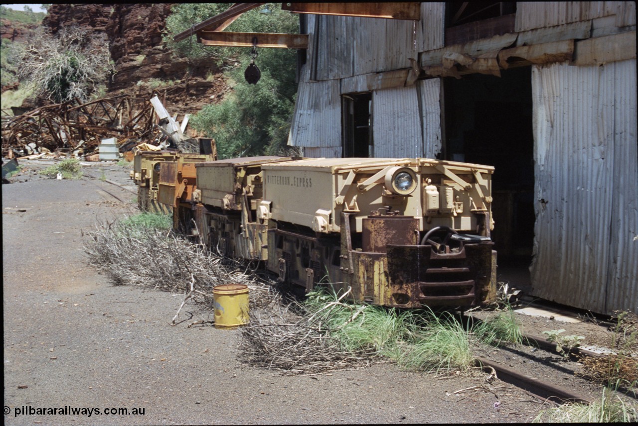 198-07
Wittenoom, Colonial Mine, asbestos mining remains, line up of two Mancha locomotives and the Gemco, then an English Electric. In the background is the demolished locomotive changing and maintenance shed. The building on the right is the compressor and water treatment plant sheds, the lead unit has Wittenoom Exprss stencilled on the battery box, this unit now resides at the Pilbara Railways Historical Society near the 7 Mile complex in Dampier.
Keywords: Mancha;English-Electric;Gemco;