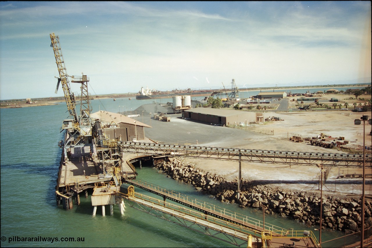 198-17
Port Hedland Port, view of the Cargill Salt berth and loader, or PHPA Berth No. 3, in this 2001 view, the then new bulker loader is under construction and manganese is stockpiled on the ground. The BHP Finucane Island berth is visible along with the overland conveyor for the HBI plant.
