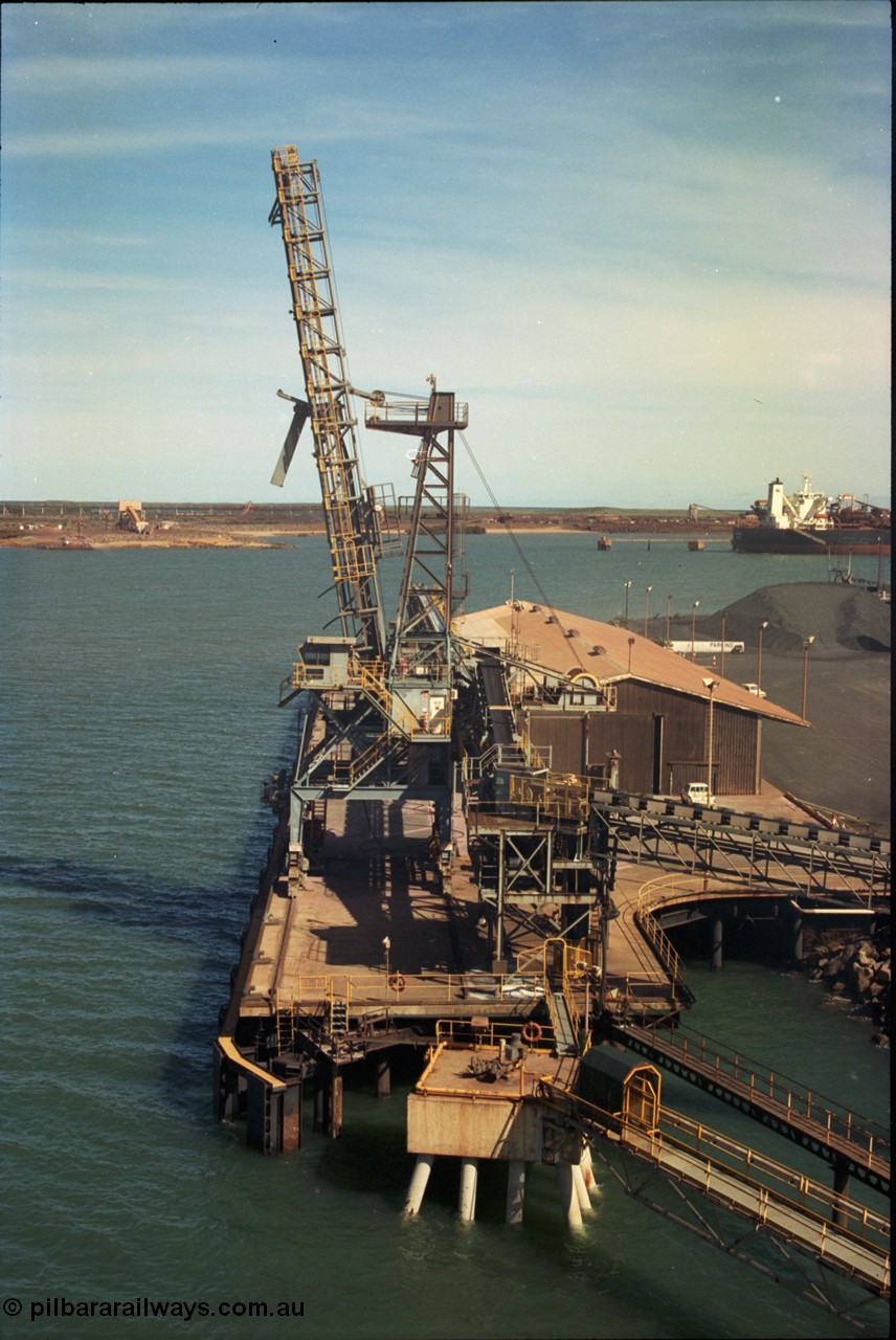 198-21
Port Hedland Port, view of the Cargill Salt berth and loader, or PHPA Berth No. 3, in this 2001 view, manganese is stockpiled on the ground. The BHP Finucane Island berth is visible along with the portal for the under-harbour tunnel and overland conveyor for the HBI plant.
