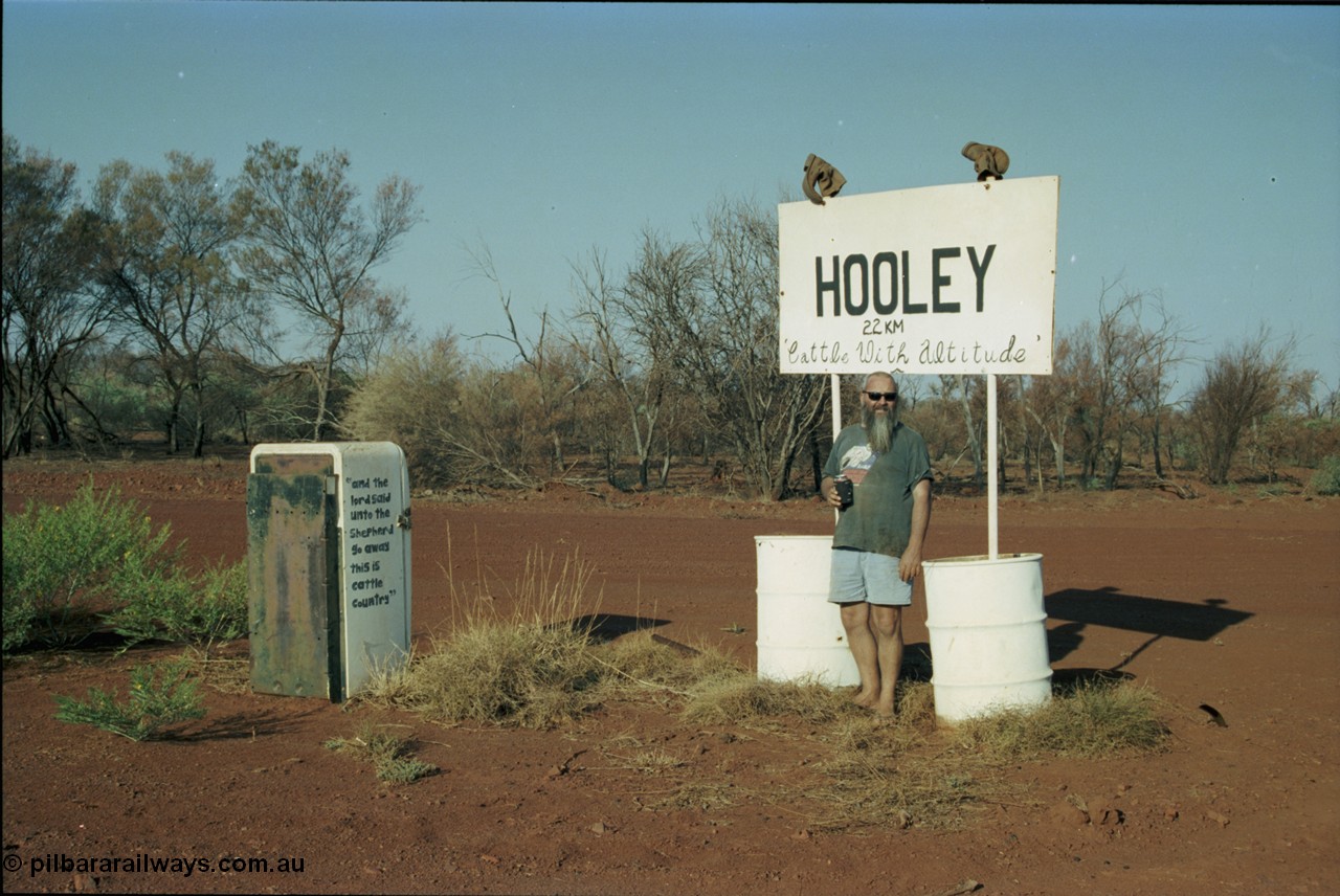 205-03
Hooley Station front gate on Roebourne - Wittenoom Road, Pope Searle celebrating with a cold beverage.
