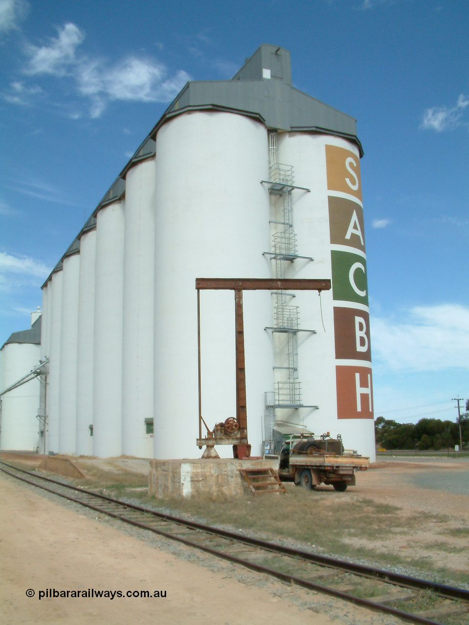 030405 132956
Wudinna, view of the 5 ton revolving jib yard crane and loading ramp with the SACBH silo complex behind and the narrow gauge siding in the foreground, 5th April 2003.
