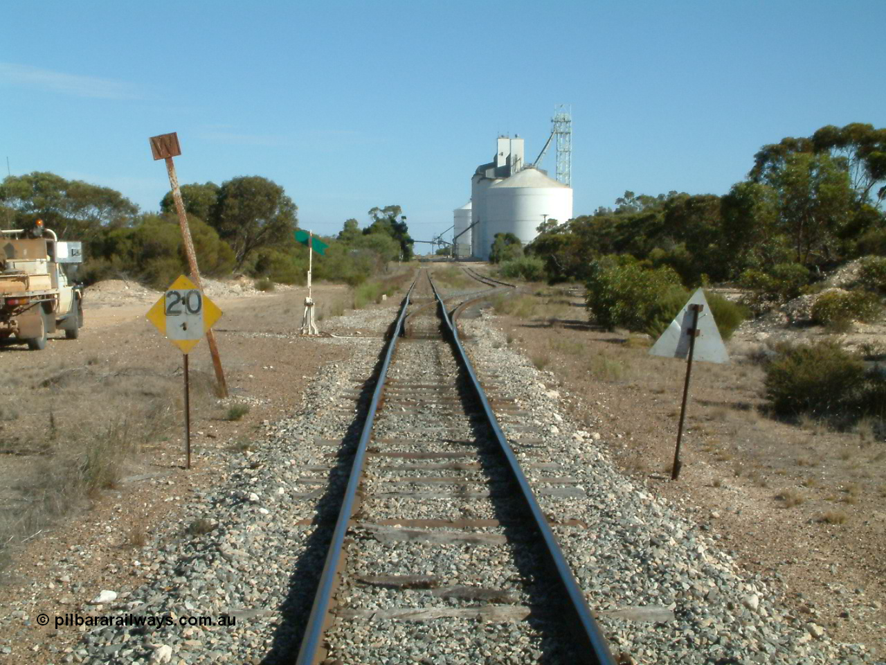 030405 154311
Lock, yard overview looking south from the northern end with speed limit and whistle boards, points and point lever and indicator for siding, silo complex visible in the background, 5th April 2003.
