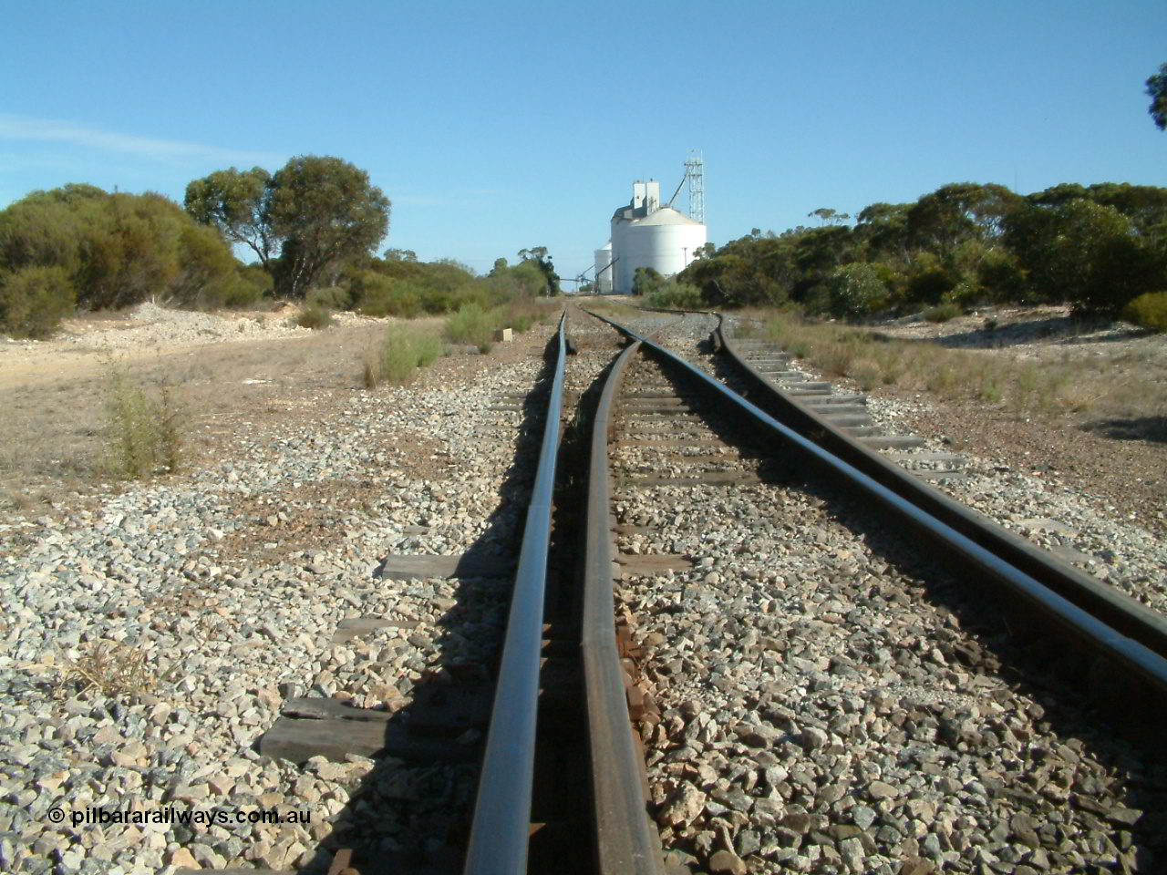 030405 154418
Lock, yard overview looking south from the northern end with a kink in the mainline with the points for the siding, silo complex visible in the background, 5th April 2003.
