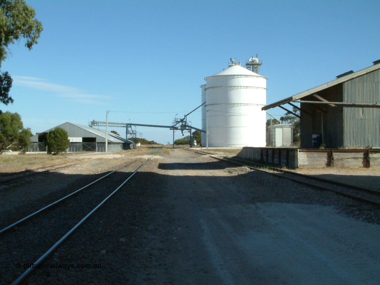 030405 155511
Lock, yard overview looking south along the mainline, horizontal grain shed with siding on the left, Ascom style silo complex Block 5 with outflow spout on the right with goods shed and platform also visible. 5th April 2003.
