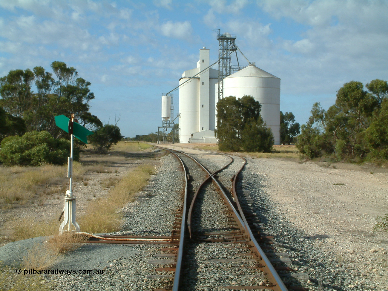 030406 083954
Tooligie, yard overview looking south from the north end points, point lever and indicator, Ascom style silo complex with outflow hopper and spout, Block 2, with concrete silo complex, Block 1, beside them. 6th April 2003.
