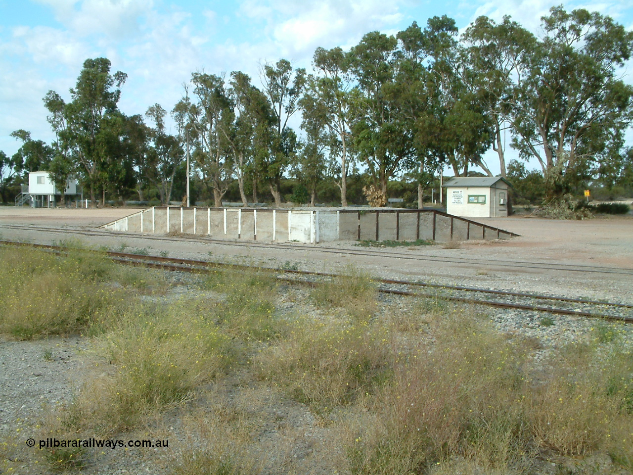 030406 084446
Tooligie, yard view looking across mainline to siding and loading ramp, weighbridge scale room in the right background. 6th April 2003.
