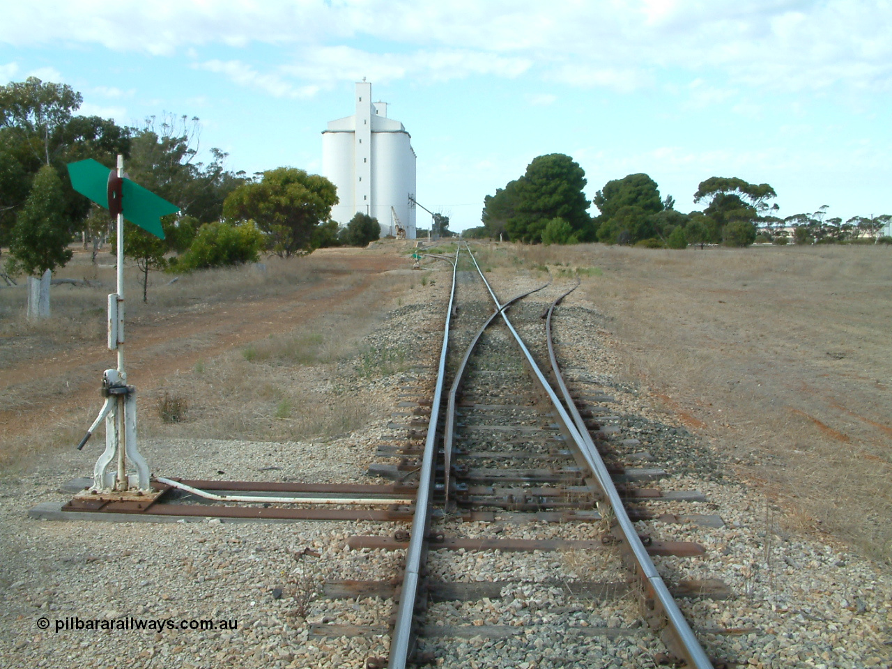 030406 091232
Yeelanna, station located at the 81.7 km, original terminus of line in April 1909, then junction for line to Mount Hope in October 1914. Station yard overview from the north end points looking south, point lever and indicators, goods ramp, crane and concrete silo complex on the left. 6th April 2003.
