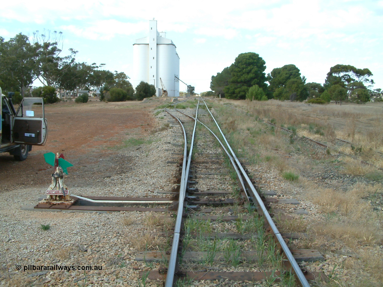 030406 091403
Yeelanna, yard overview looking south from the goods siding north end points, leaver and indicator, goods ramp with crane and concrete silo complex. 6th April 2003.
