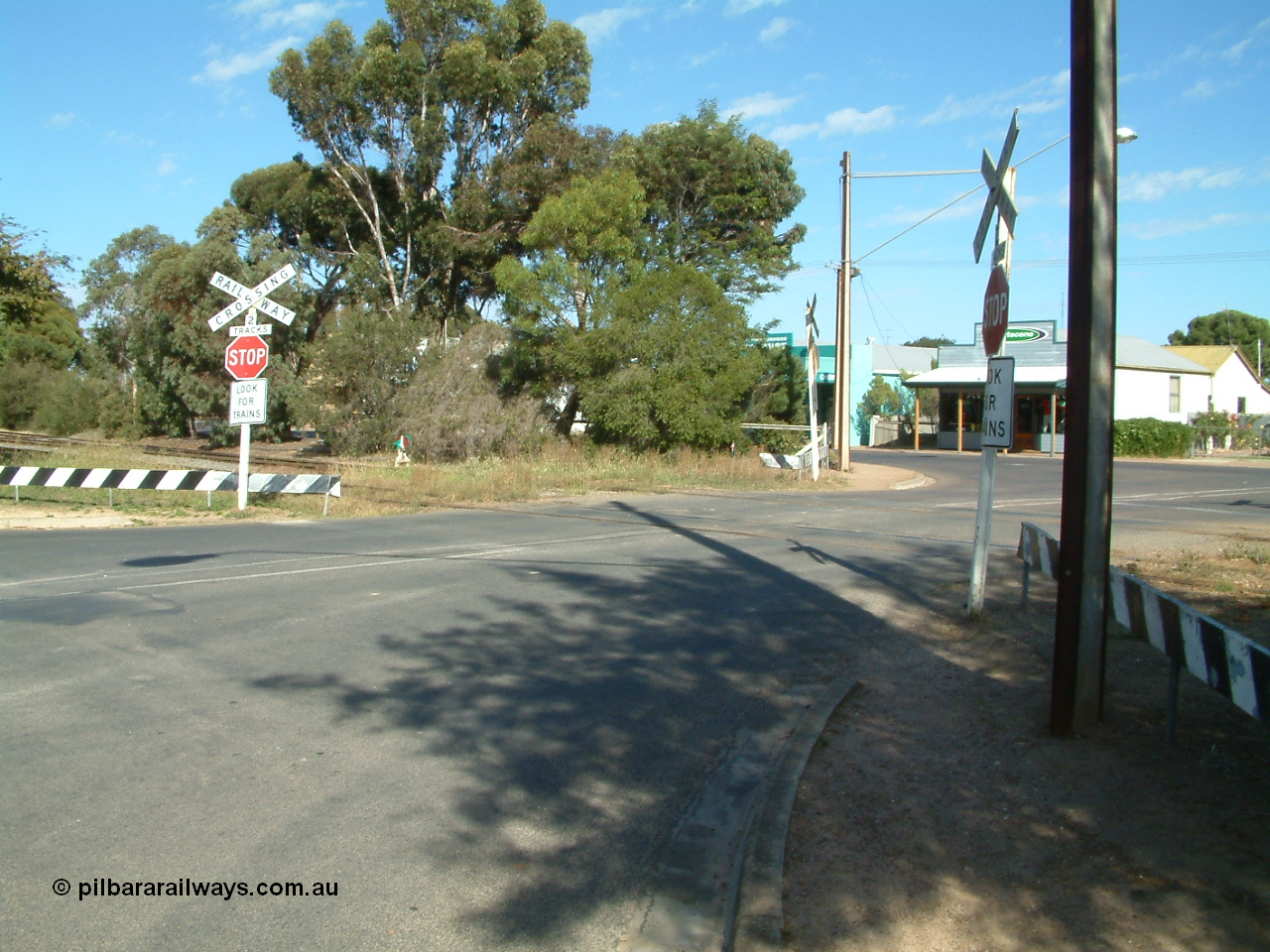 030406 094958
Cummins, Hall Street grade crossing, looking south, point lever and indicator visible for the grain siding off the mainline, branch line to Buckleboo is the near track. 6th April 2003.
