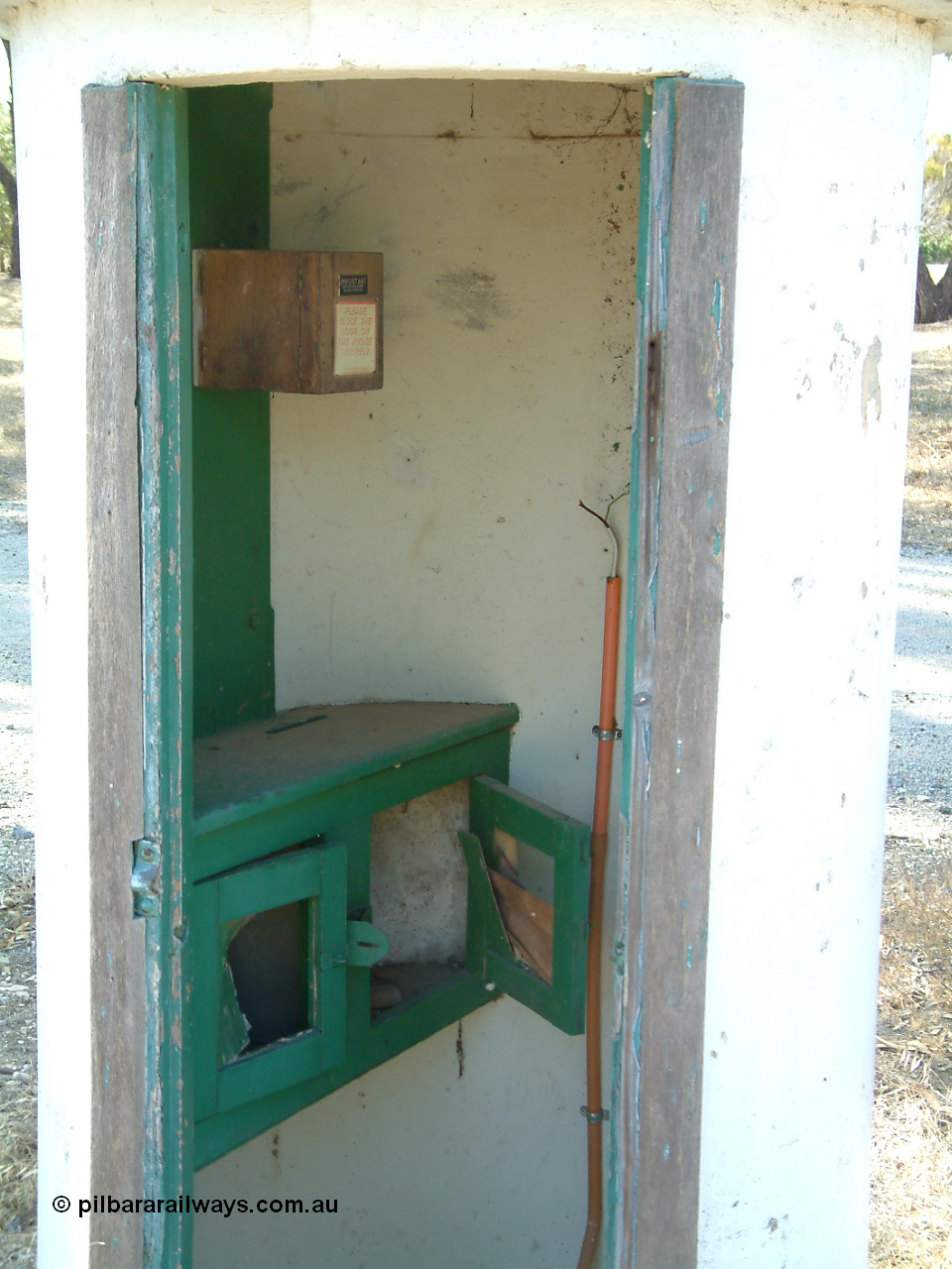 030406 095944
Cummins, view inside the concrete train control booth, shows writing desk and box on wall with phone inside. 6th April 2003.
