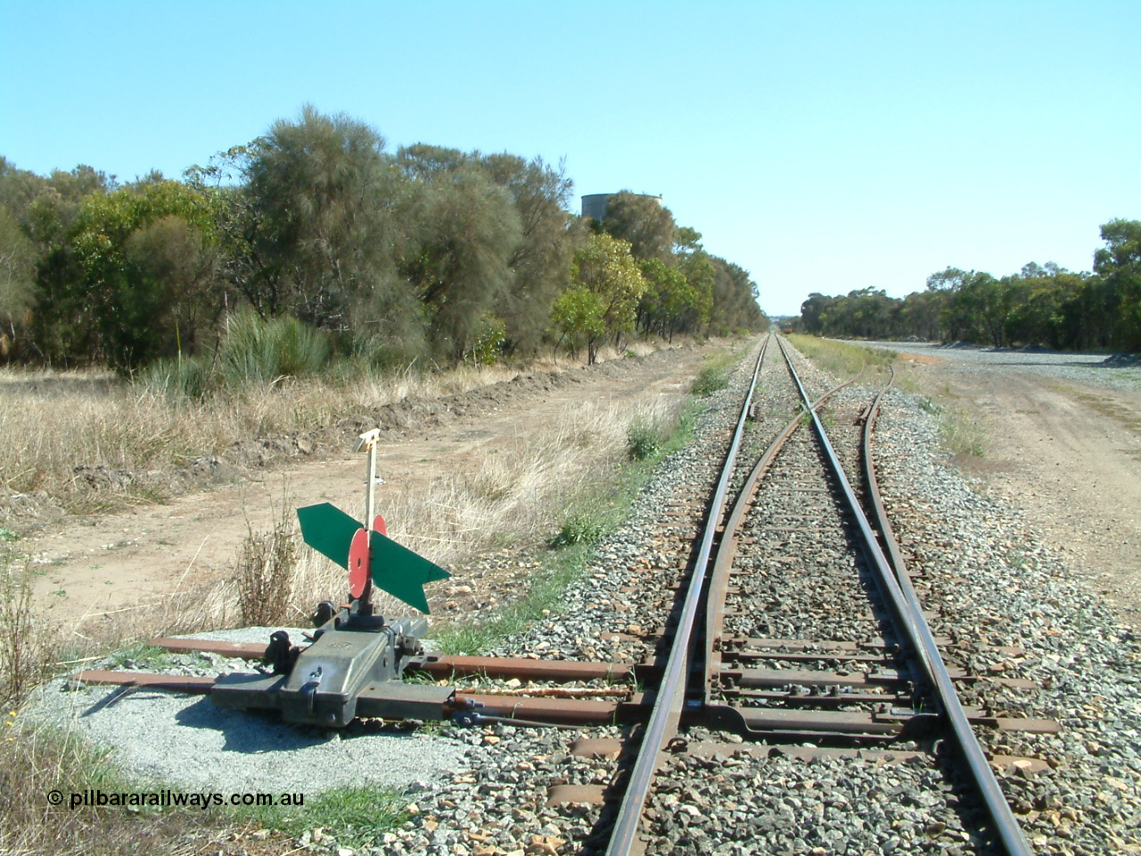 030406 105948
Coomunga, station located at the 21.6 km, opened in November 1907, used these days as a track maintenance siding. Yard overview looking north from the south end points, water tank on the left, track machines in the distance on the right. 6th April 2003.
