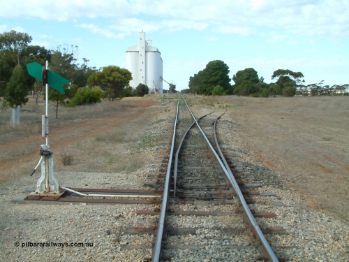 030406 091232
Yeelanna, station located at the 81.7 km, original terminus of line in April 1909, then junction for line to Mount Hope in October 1914. Station yard overview from the north end points looking south, point lever and indicators, goods ramp, crane and concrete silo complex on the left. April 6, 2003.
