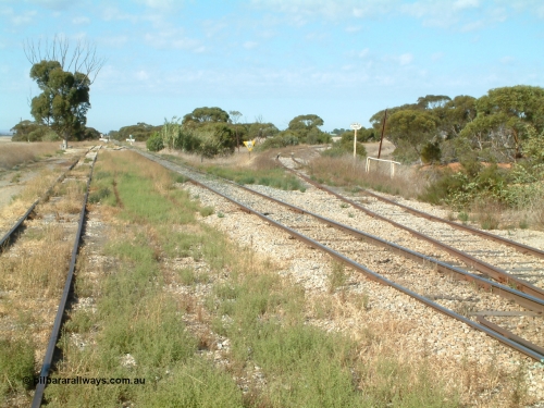 030406 092756
Yeelanna, yard view looking south, shows mainline and grain siding running south and branch line to Kapinnie and former Mount Hope branch curving away to the right across a culvert and past a cast Yard Limit sign. April 6, 2003.
