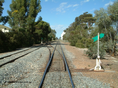 030406 094714
Cummins, yard overview looking south down the mainline from Thevenard with the line from Buckleboo coming in on the left, points, levers and indicators for the crossovers being visible with crib crossing and concrete silos in the distance. April 6, 2003.
