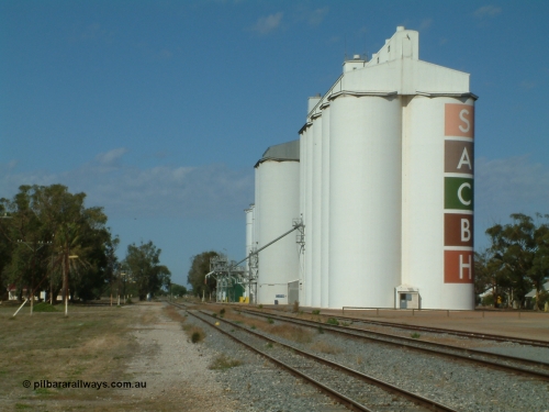 030406 095408
Cummins, view of the three grain storage silo complexes, looking south along the old alignment for the fourth siding, and barracks at the left of frame. April 6, 2003.
