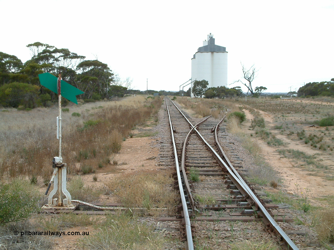 030407 085902
Yaninee, station yard overview looking south for the north end, concrete SACBH silo complexes, points, lever and indicator, train control booth and shelter visible on the left. 7th April, 2003.
