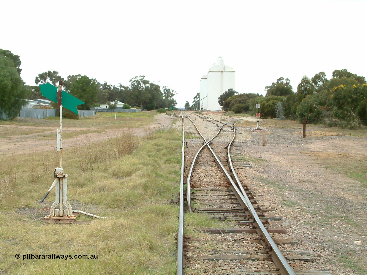 030407 095119
Minnipa, station yard overview looking south from the north end points, point levers and indicators for Sidings 1, 2 and 3 visible. Concrete silo complexes and rotating jib crane visible in the distance. 7th April 2003
