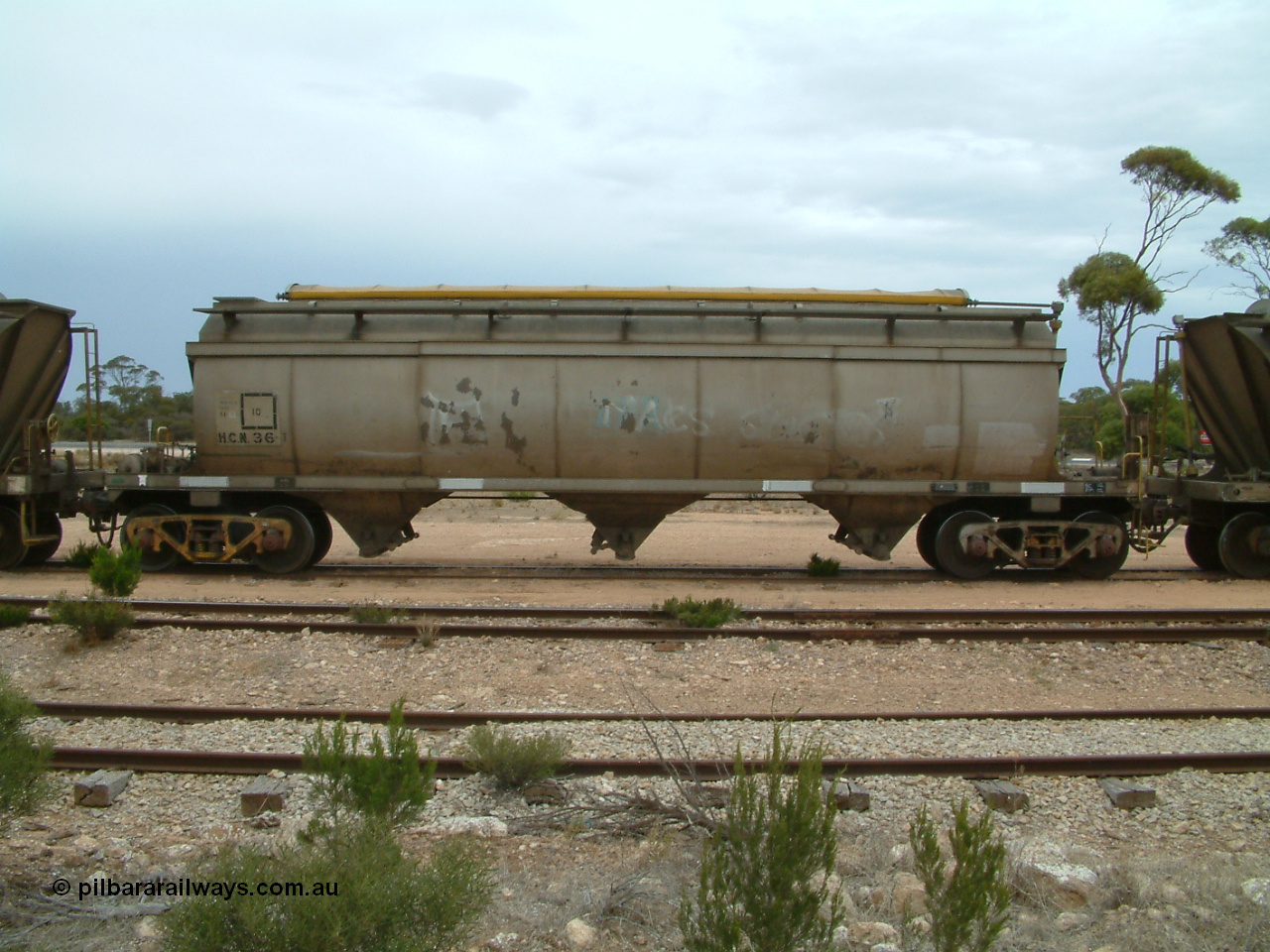 030407 105517
Poochera, track view and side view of HCN type bogie wheat waggon HCN 36, modified at Islington Workshops in 1978-80 which started life as a Tulloch built NHB type iron ore hopper for the CR on the North Australia Railway in 1968-69, showing the roll top covers. 7th April 2003.
Keywords: HCN-type;HCN36;SAR-Islington-WS;rebuild;Tulloch-Ltd-NSW;NHB-type;NHB1592;