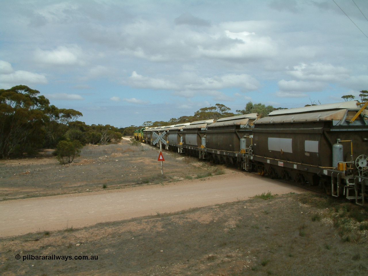 030409 115636
Darke Peake, at the 195 km Dog Fence Road grade crossing loaded grain train with 830 class unit 851 AE Goodwin ALCo model DL531 serial 84137, 851 has spent its entire operating career on the Eyre Peninsula, leads fellow 830 class 842 serial 84140 and a rebuilt unit DA 4, rebuilt from 830 class unit 839 by Port Augusta Workshops, retains original serial 83730 and model DL531 with the first twelve waggons behind the locos XNW type.
