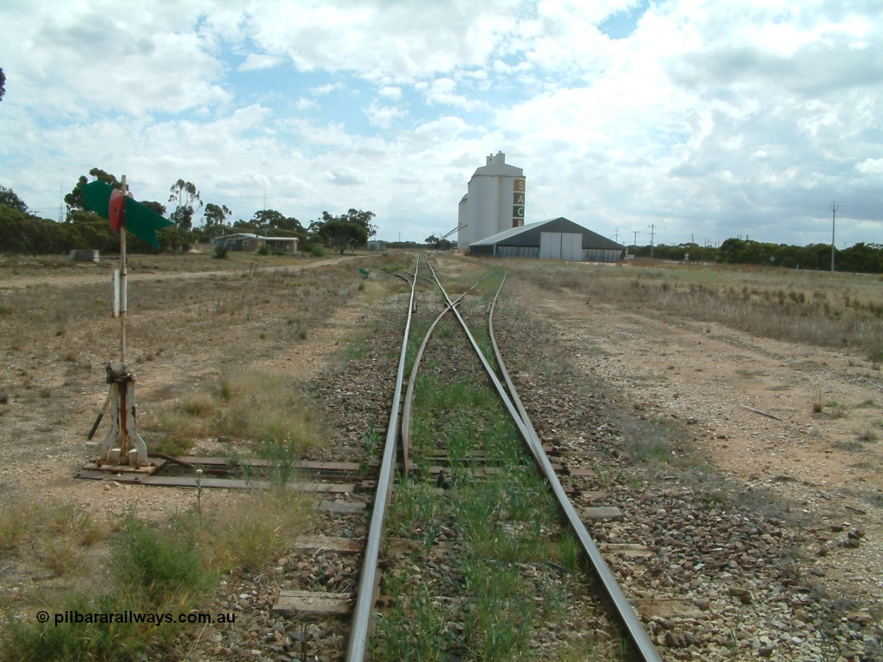 030409 125154
Rudall, station overview of yard looking north from the south end, points to the right for the goods and grain siding, the former station loop, now stub siding on the left, crew barracks and station building further on can be made out, horizontal grain bunker on the right with concrete silo complexes behind.
