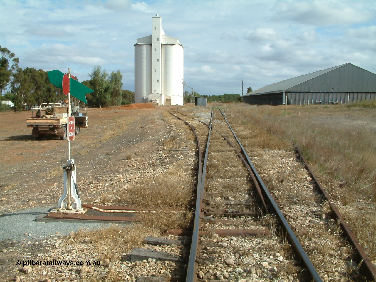 030409 145852
Ungarra, located at the 108.1 km and opened in March 1913 as the temporary terminus till July 1913. Yard overview looking south from the goods and grain loop points, loading ramp can be made out in front of car, silo complex, station hut then the horizontal grain bunker on the right.
