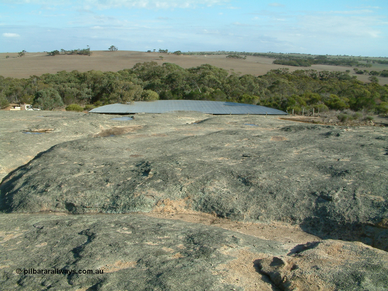 030409 155132
Moody Tank, view of the granite rock which acts as the catchment for the tank, water can be seen in pools, the line is below within the trees.
