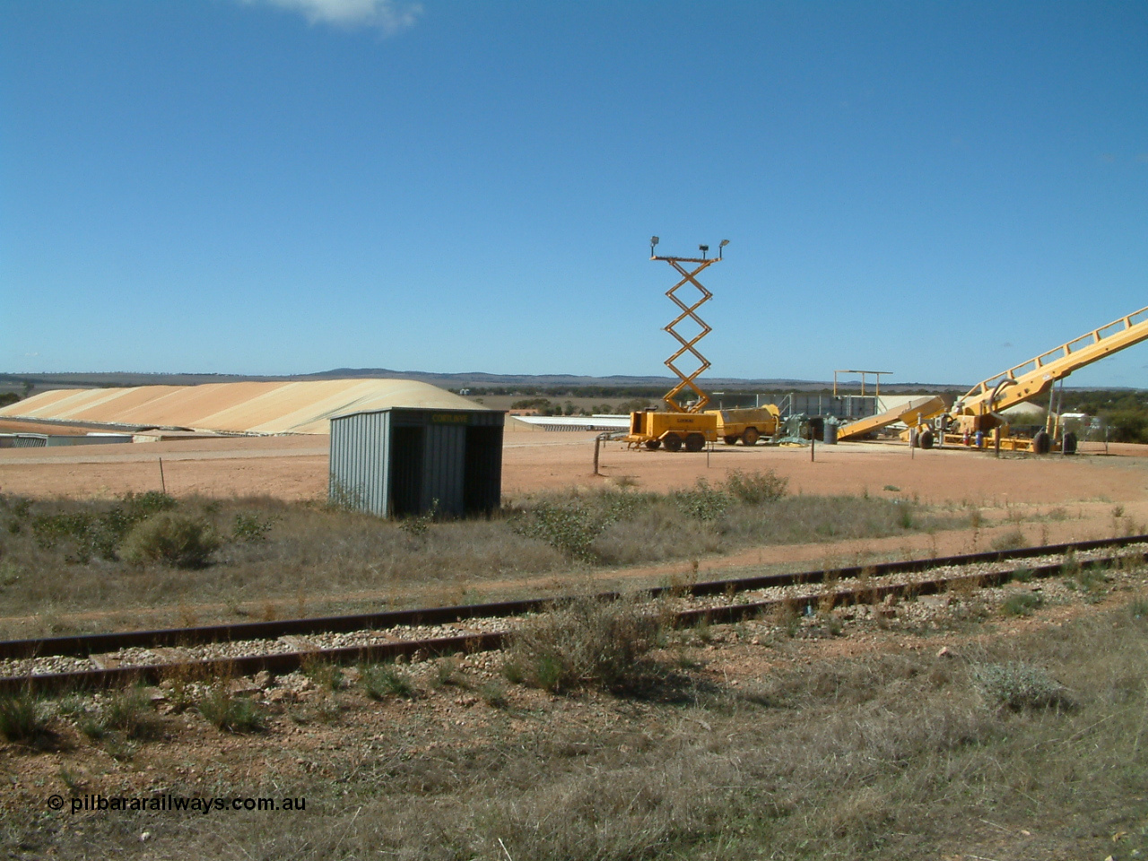 030411 105119
Kimba Grain Bunker site, overview of arrangement. Former Cortlinye shelter placed for crew, lighting tower for night time operation and the yellow auger goes to the over rail loadout bin.
