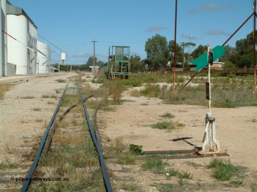 030411 105828
Kimba, station yard, view of rail transport set in the loading road, winch waggon, dumbbell point indicator. Barracks visible behind indicator, station building in the distance.
