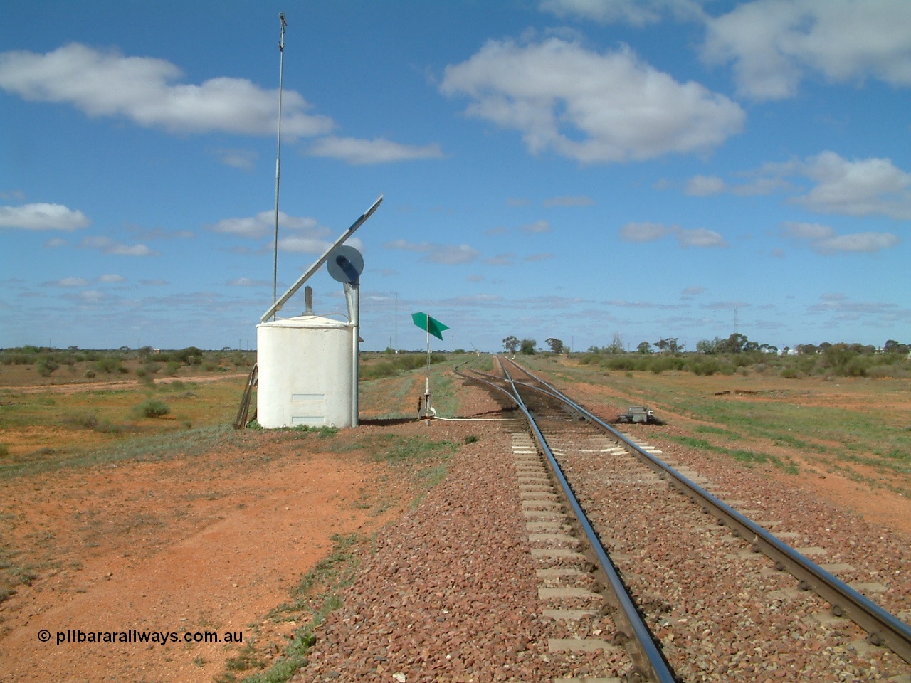 030415 140558
Kingoonya, located at the 426.5 km on the Trans Australian Railway, looking east from the western end of the 1800 metre long crossing location, interlocking hut with searchlight signal, solar array, point indicator and dual control point machine. The timber sleepers for the point work clearly evident, town off to the right. [url=https://goo.gl/maps/rY8C9mU9iF4tBmjF7]GeoData location[/url].
