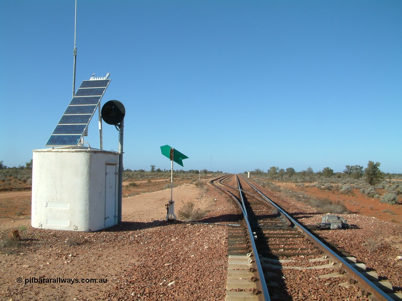 030416 084506
Carnes Siding located at the 566.4 km on the Central Australian line from Tarcoola to Alice Springs. Looking south from the north end of the loop, interlocking hut with repeater searchlight signal, point indicator and dual control point machine, in the distance the north end train control 'pillbox' can be seen. [url=https://goo.gl/maps/UV5pRwSrTaW3bxA76]GeoData location[/url]. 16th April 2003.
