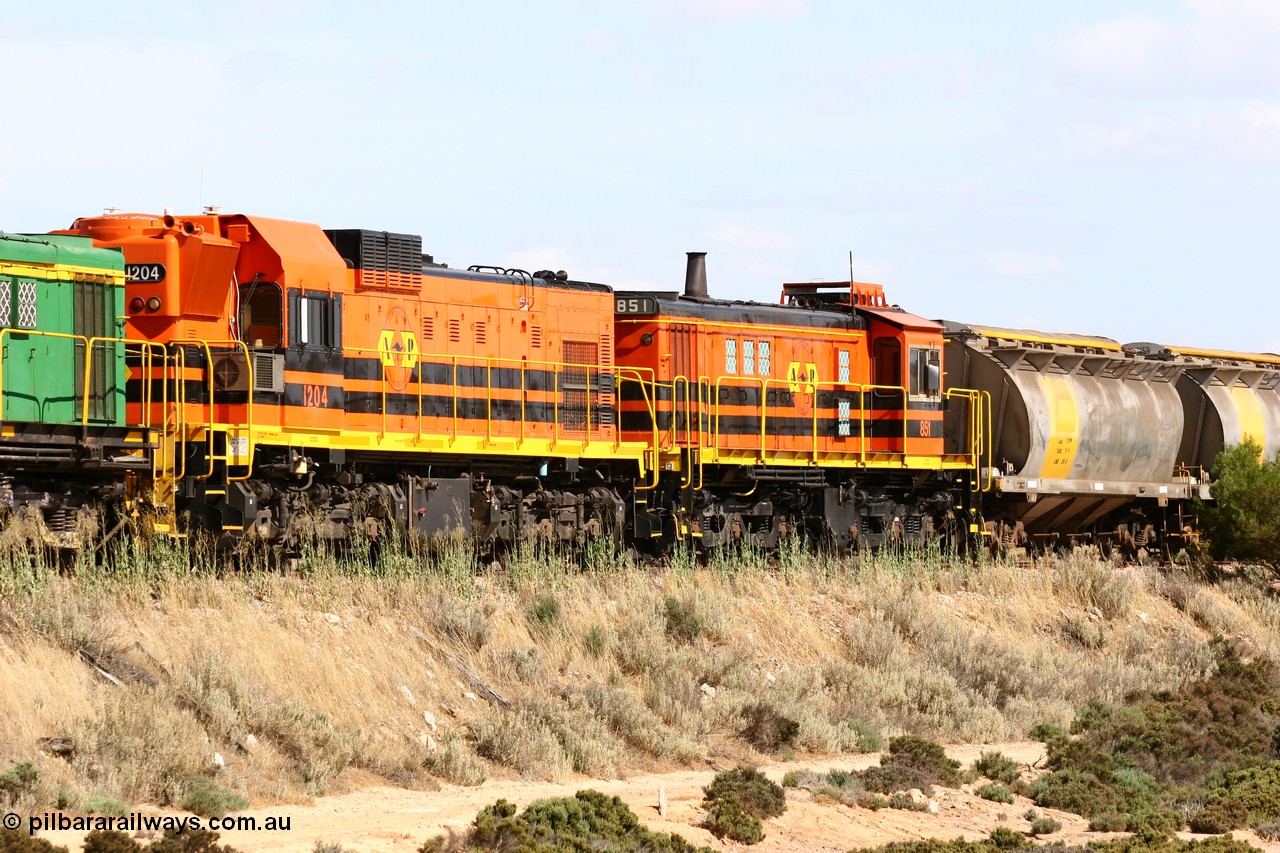 060109 2098
Kyancutta at the 198 km, ARG 1200 class unit 1204, a Clyde Engineering built EMD model G12C serial 65-428 and the final of fourteen originally built between 1960-65 for WAGR as their A class unit A 1514, fitted with dynamic brakes and financed by Western Mining Corporation was transferred to the Eyre Peninsula in August 2004, due to cab air conditioning problems it is second unit with ALCo 830 class 851 behind it with a north bound empty grain train. 9th January 2006.
Keywords: 1200-class;1204;Clyde-Engineering-Granville-NSW;EMD;G12C;65-428;A-class;A1514;