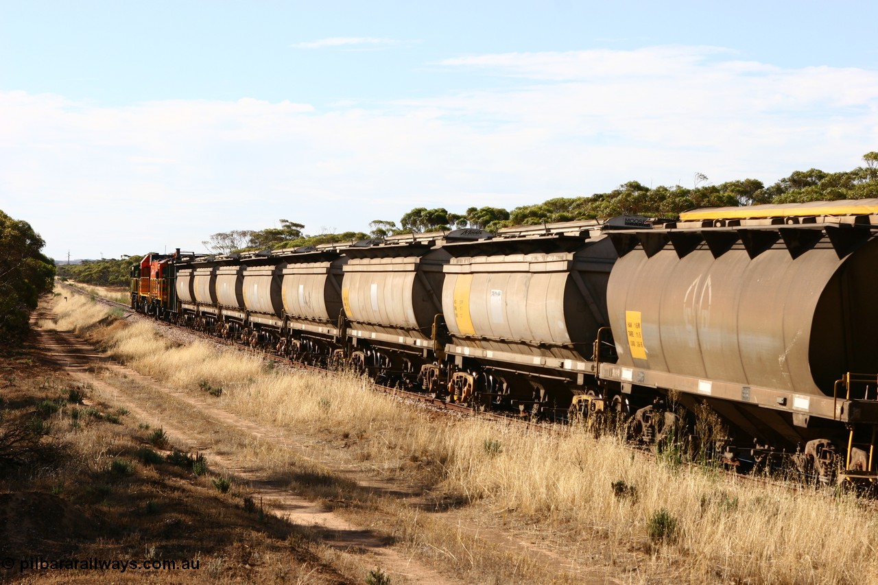 060109 2149
Wannamana, view looking towards the front of the train along a string of seven HCN type bogie wheat waggons, modified at Islington Workshops in 1978-80 which started life as a Tulloch built NHB type iron ore hopper for the CR on the North Australia Railway in 1968-69, an SAR built HAN type HAN 16 is following them [url=https://goo.gl/maps/43EOs]on the curve[/url]. 9th January 2006.
Keywords: HCN-type;HAN-type;Tulloch-Ltd-NSW;NHB-type;