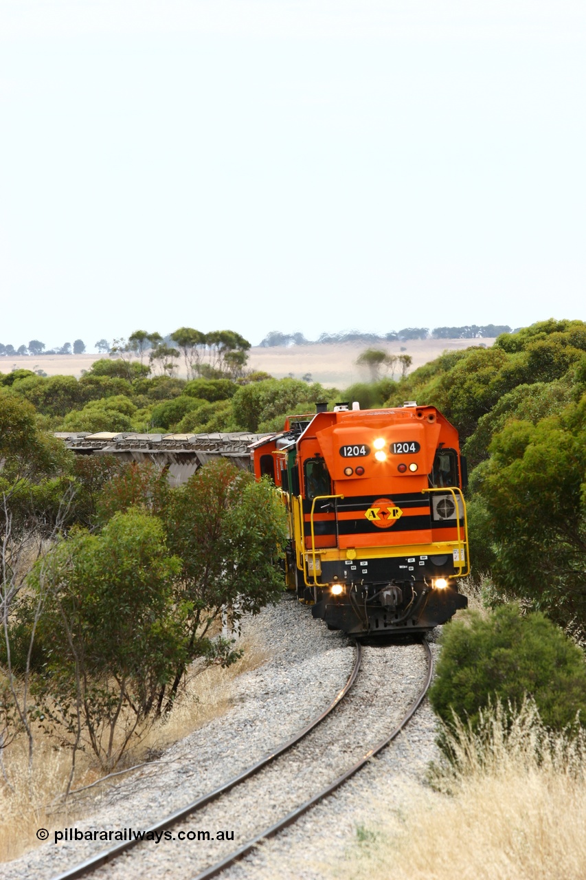 060110 2209
On the curve near the 85 km between Yeelanna and Karkoo, ARG 1200 class unit 1204, a Clyde Engineering EMD model G12C serial 65-428, originally built for the WAGR as the final unit of fourteen A class locomotives in 1965 and sent to the Eyre Peninsula in July 2004 leads an empty grain train. [url=https://goo.gl/maps/7kwfXBE6nS12]Approx. location of image[/url].
Keywords: 1200-class;1204;Clyde-Engineering-Granville-NSW;EMD;G12C;65-428;A-class;A1514;