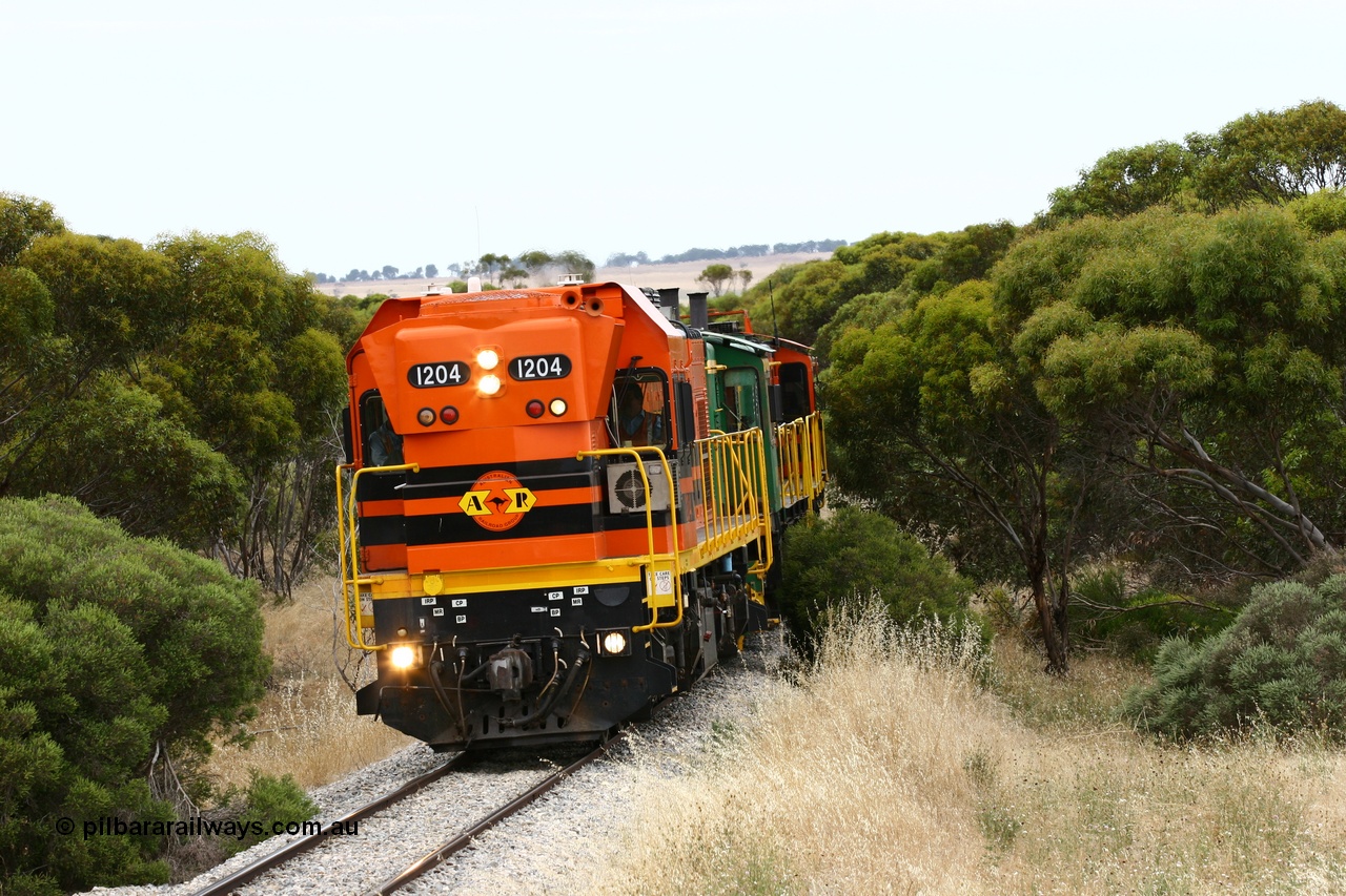 060110 2211
On the curve near the 85 km between Yeelanna and Karkoo, ARG 1200 class unit 1204, a Clyde Engineering EMD model G12C serial 65-428, originally built for the WAGR as the final unit of fourteen A class locomotives in 1965 and sent to the Eyre Peninsula in July 2004 leads an empty grain train. [url=https://goo.gl/maps/7kwfXBE6nS12]Approx. location of image[/url].
Keywords: 1200-class;1204;Clyde-Engineering-Granville-NSW;EMD;G12C;65-428;A-class;A1514;