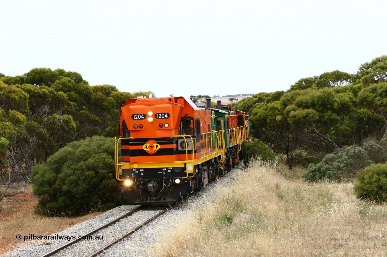 060110 2212
On the curve near the 85 km between Yeelanna and Karkoo, ARG 1200 class unit 1204, a Clyde Engineering EMD model G12C serial 65-428, originally built for the WAGR as the final unit of fourteen A class locomotives in 1965 and sent to the Eyre Peninsula in July 2004 leads an empty grain train. [url=https://goo.gl/maps/7kwfXBE6nS12]Approx. location of image[/url].
Keywords: 1200-class;1204;Clyde-Engineering-Granville-NSW;EMD;G12C;65-428;A-class;A1514;