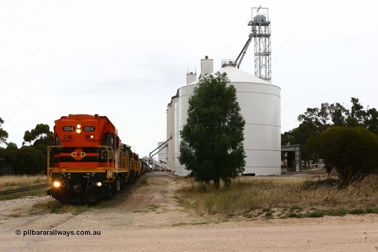 060110 2240
Lock, grain train loading underway behind ARG 1200 class unit 1204, a Clyde Engineering EMD model G12C serial 65-428, originally built for the WAGR as the final unit of fourteen A class locomotives in 1965 and sent to the Eyre Peninsula in July 2004 and two 830 class AE Goodwin built ALCo model DL531 units 842 serial 84140 ex SAR broad gauge and to Eyre Peninsula in October 1987, and 851 serial 84137 new to Eyre Peninsula in 1962. An Ascom silo complex is closest to camera. [url=https://goo.gl/maps/epTNTP7PARy]Approx. location of image[/url].
Keywords: 1200-class;1204;Clyde-Engineering-Granville-NSW;EMD;G12C;65-428;A-class;A1514;