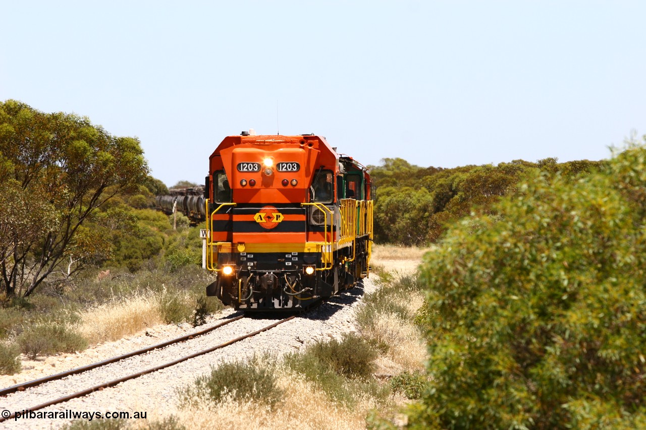 060111 2245
Tooligie, Mac's Road grade crossing at the 110 km, ARG 1200 class unit 1203, a Clyde Engineering EMD model G12C serial 65-427, one of fourteen originally built between 1960-65 for WAGR as their A class A 1513, fitted with dynamic brakes and financed by Western Mining Corporation, started working on the Eyre Peninsula in November 2004 leads an empty grain train north. 11th January 2006.
Keywords: 1200-class;1203;Clyde-Engineering-Granville-NSW;EMD;G12C;65-427;A-class;A1513;