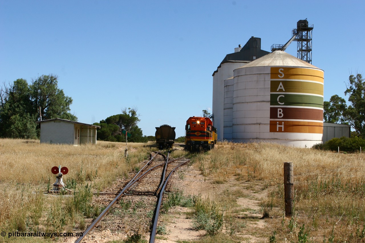 060111 2322
Warramboo, located at the 190.2 km with now disused station building on the left, Clyde Engineering built EMD G12C model loco 1203 serial 65-427 shunts empty grain waggons into the grain loop for loading. 11th January 2006.
Keywords: 1200-class;1203;Clyde-Engineering-Granville-NSW;EMD;G12C;65-427;A-class;A1513;